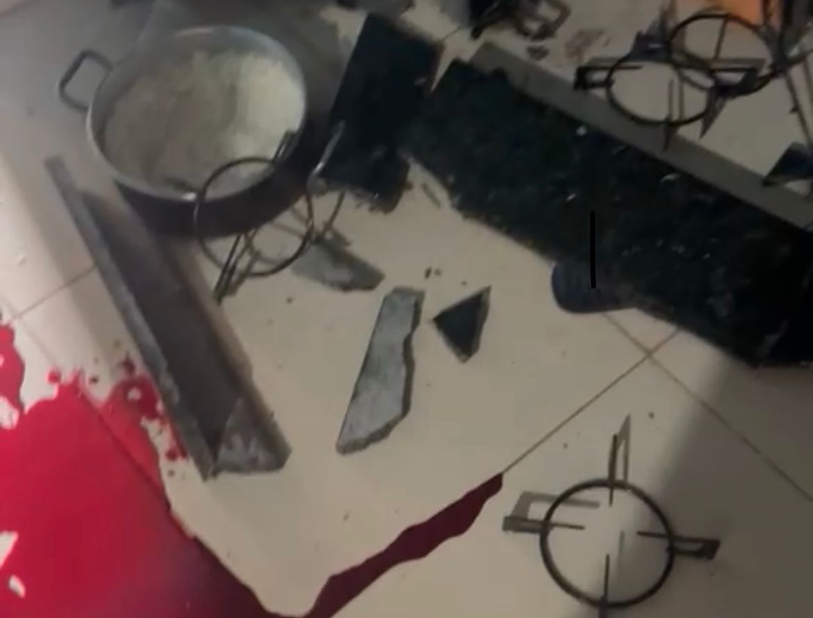 Fogão do tipo cooktop ficou destruído ao lado de panelas e o chão sujo de sangue (Foto: Reprodução)