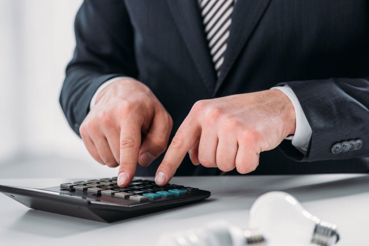 foto ilustrativa de homem usando calculadora