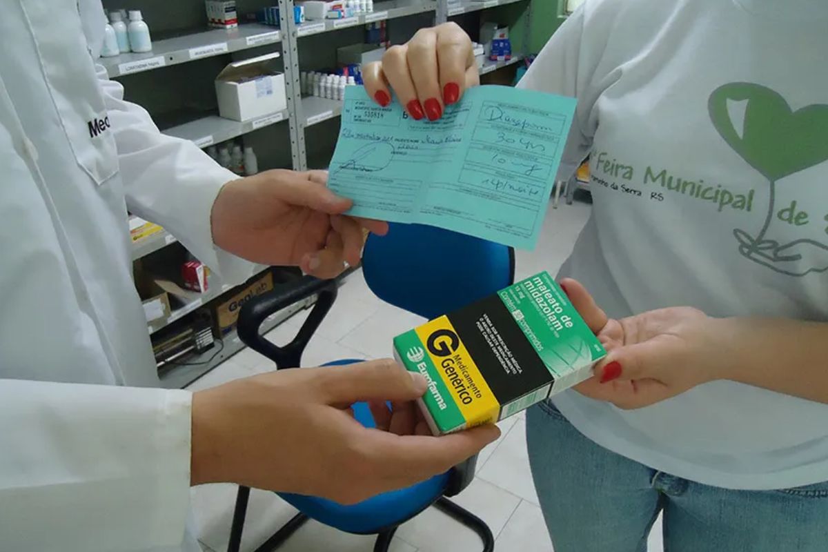foto de pessoa pegando medicamento com médico com receita em mãos