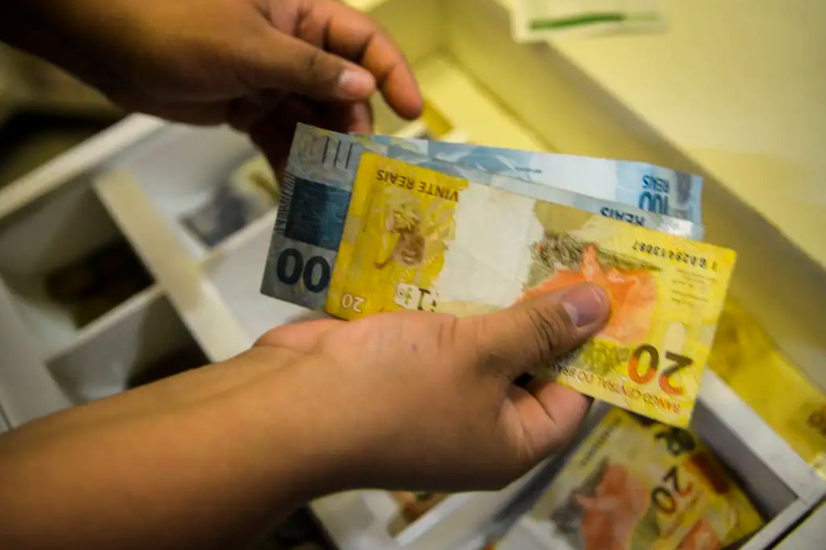 foto do pessoa sacando dinheiro de caixa eletrônico