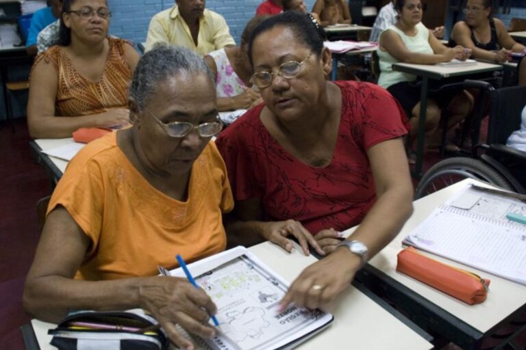 foto para ilustrar matéria do encceja 2025 com pessoas mais velhas estudando em livro