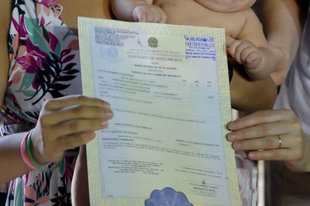 foto de pessoas segurando registro de nascimento