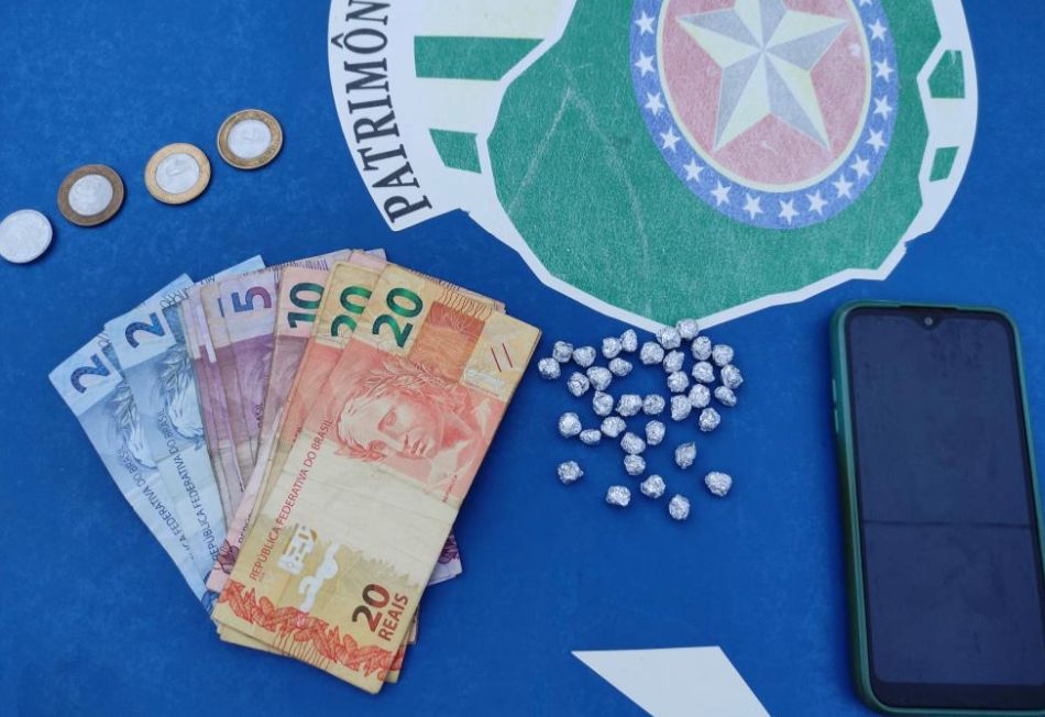 Porções de crack, dinheiro e um celular foram apreendidos com o suspeito (Foto: Divulgação-PM)