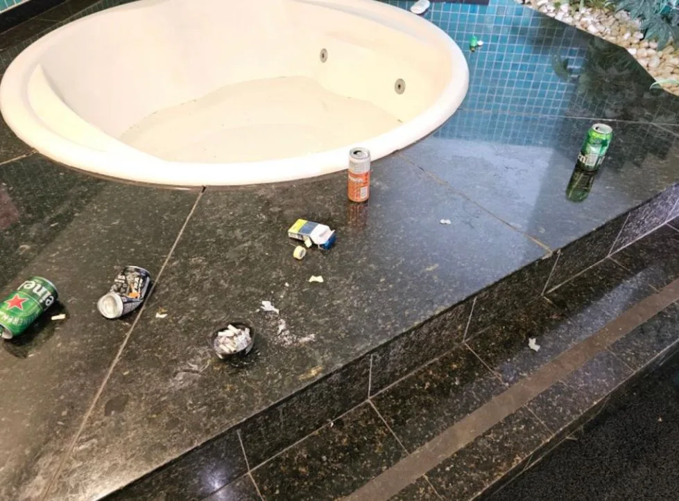 Cigarros e latas de energético e cerveja ao lado da banheira da suíte (Foto: Reprodução)