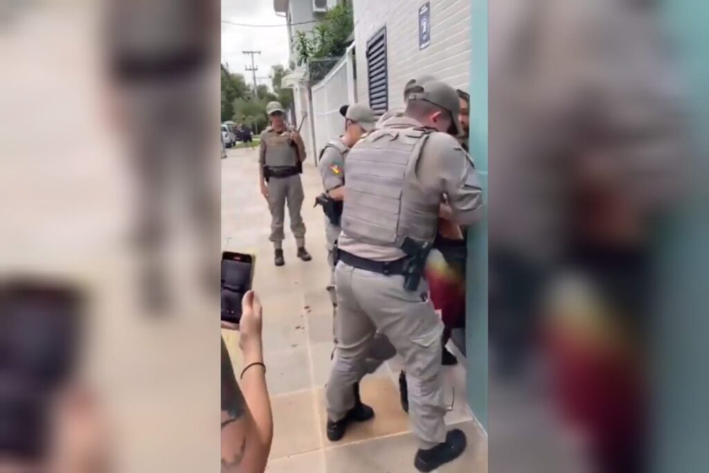 O motoboy foi levado à delegacia no camburão, já o idoso foi conduzido no banco de trás da viatura (Foto: Captura)