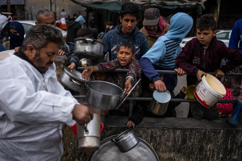 Nesta imagem, palestinos aguardam para receber alimentos no mesmo local onde ocorreu o ataque, em Gaza. (Foto: Reprodução / AP)