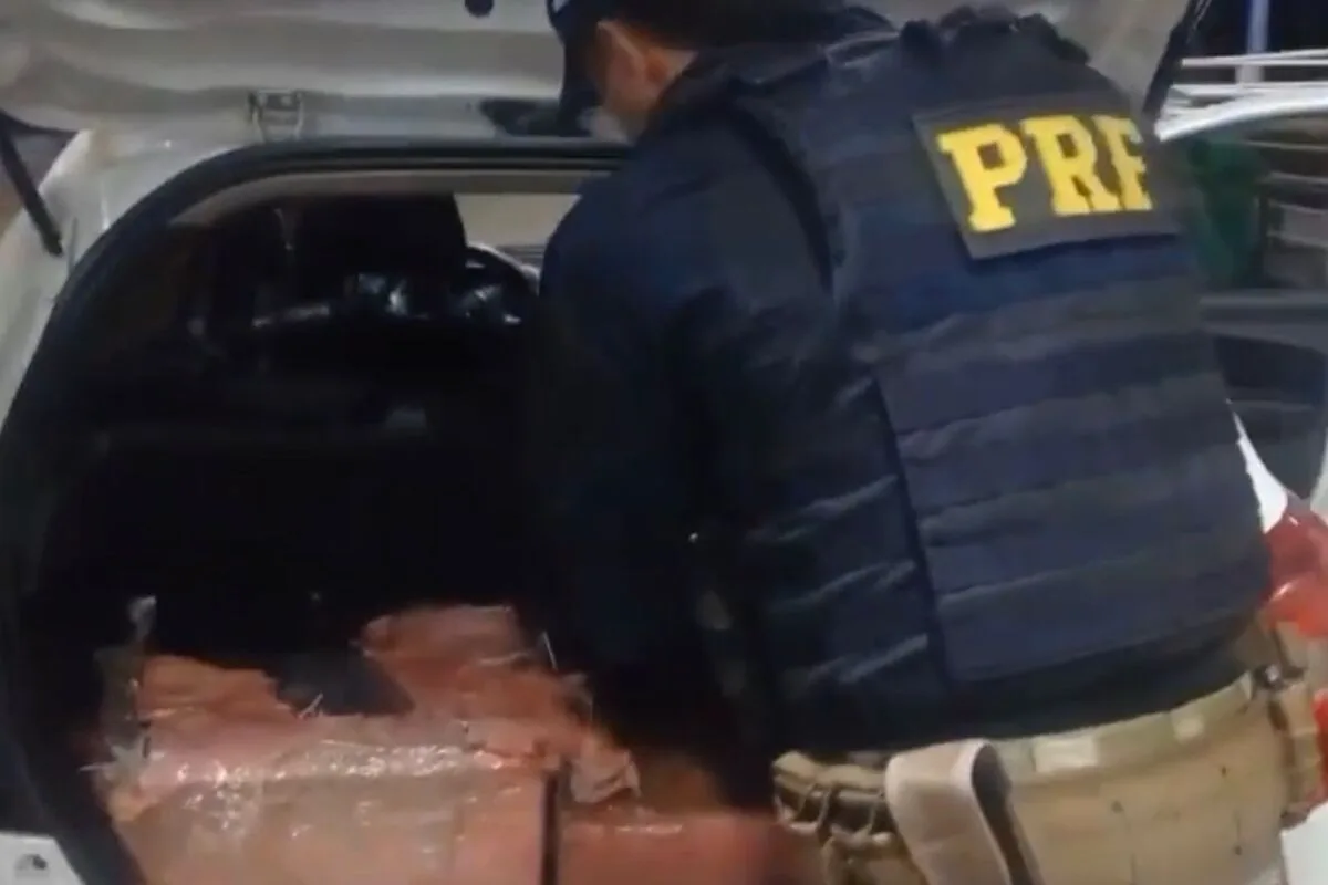 Policiais descobriram os pacotes de cloridrato de cocaína, escondidos no porta-malas (Foto: Divulgação/PRF)