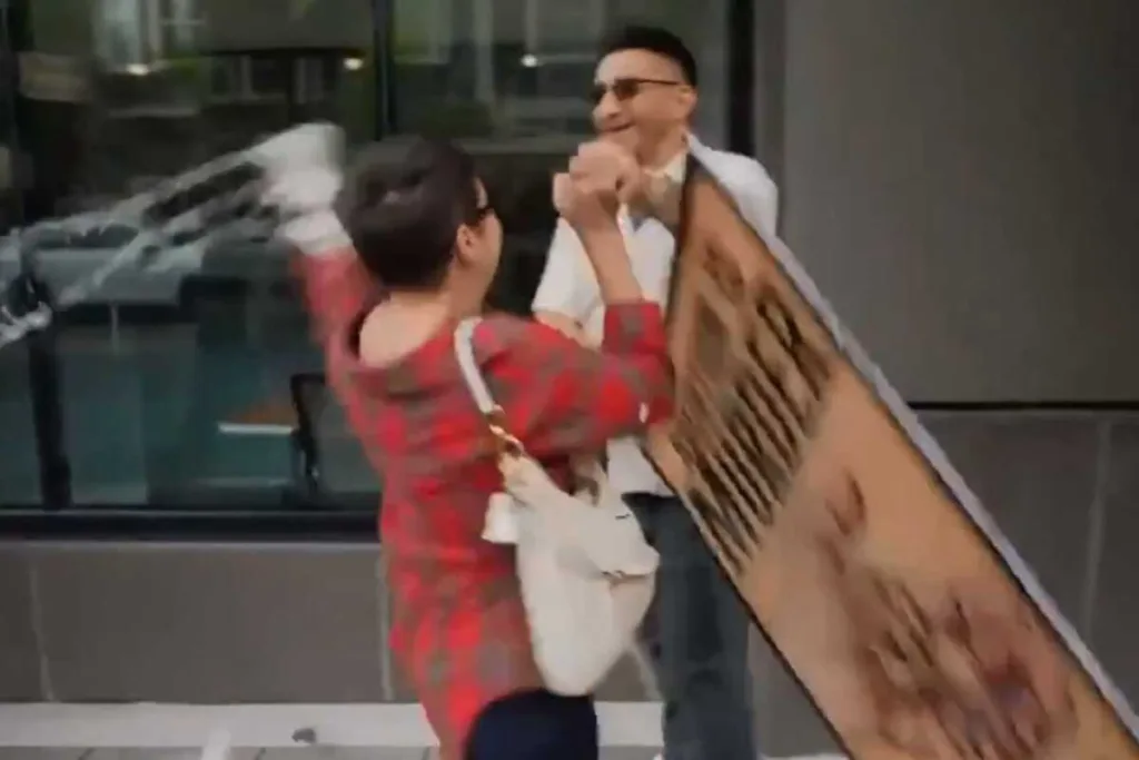 Em uma legenda inserida no vídeo, o manifestante indica que a mulher também tentou agredir a auxiliar que registrava a cena. (Foto: Captura)