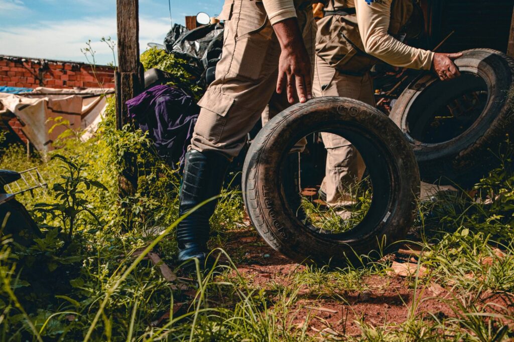 foto de agente de endemia mexendo em pneu em lote baldio