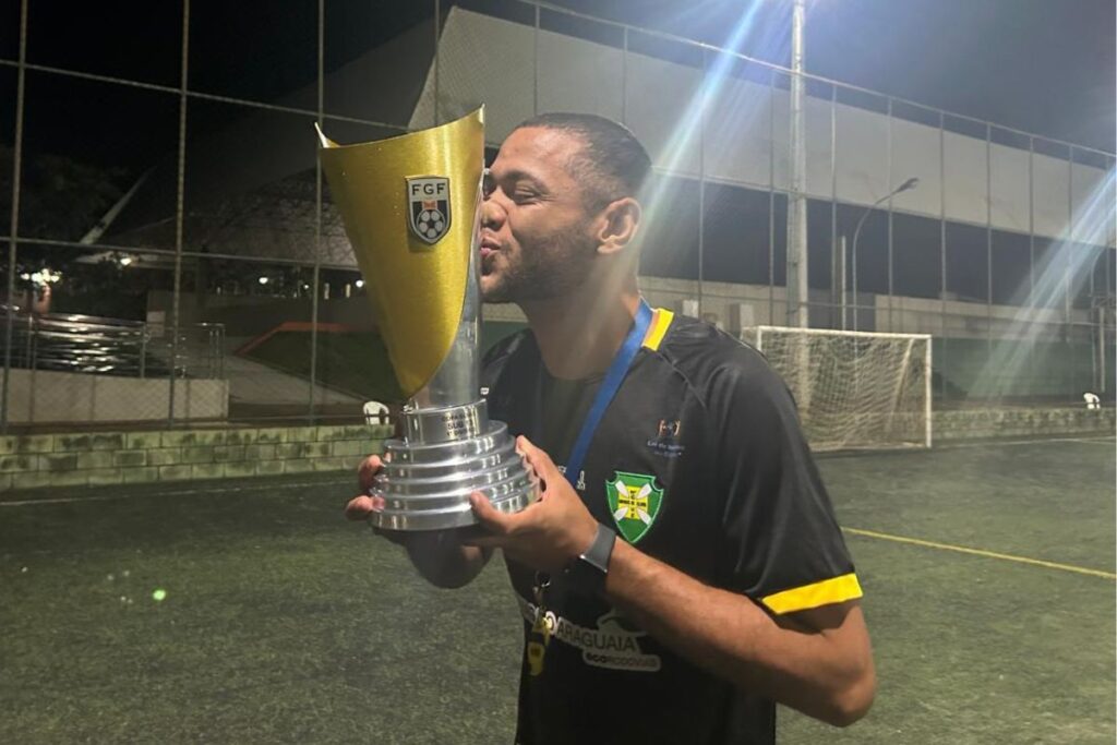 foto do treinador Caio Vinícius, do Santa Cruz, beijando troféu da Copa Goiás Sub-13