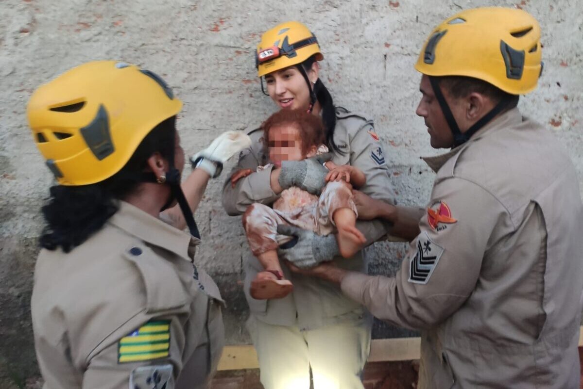 foto de guarnição do corpo de bombeiros com criança resgatada de buraco