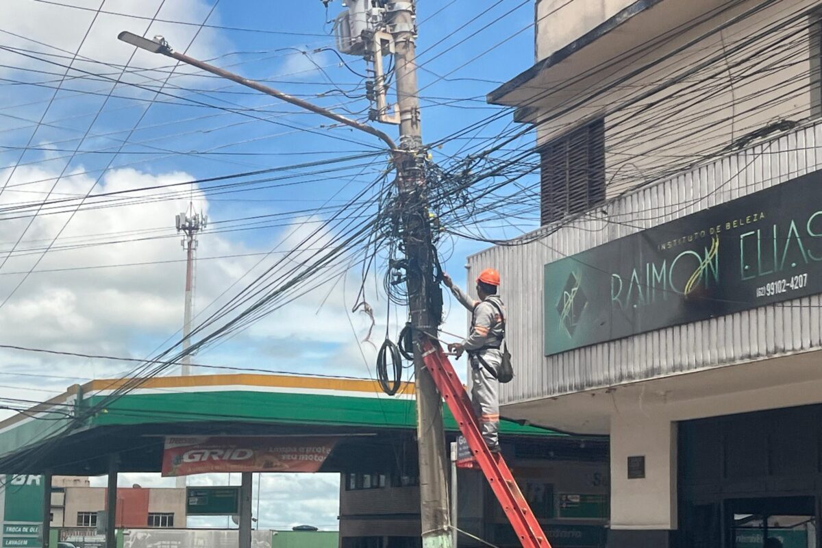 foto de homem manipulando cabos e fios em poste de Anápolis