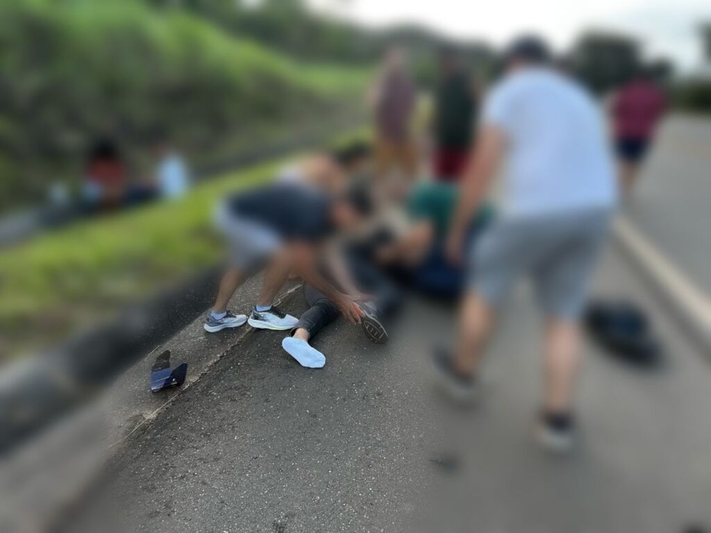 Populares que passavam pela rodovia tentaram ajudar a motociclista (Foto: Reprodução)