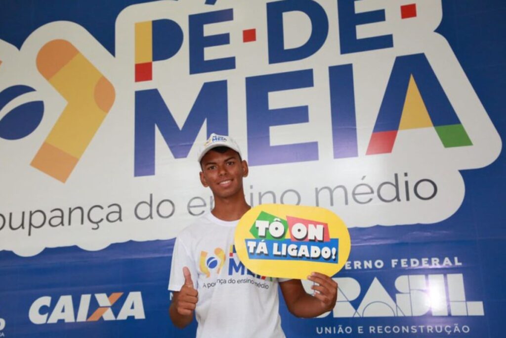 foto de estudante com banner do programa pé-de-meia